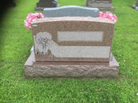Stone grave marker with pink flowers on top