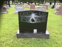 Black granite headstone with ornate carved details