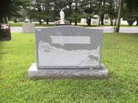 Gray granite headstone with etched landscape scene